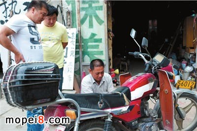 大莊在幫顧客檢查摩托車的問題