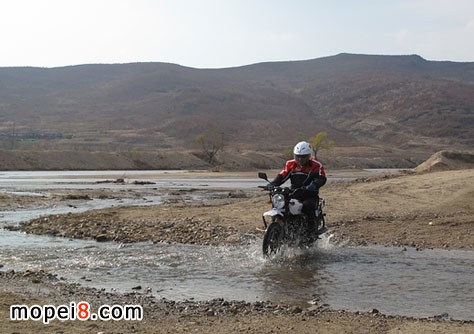 在朝鮮境內王龍祥正駕駛著摩托車駛過小河